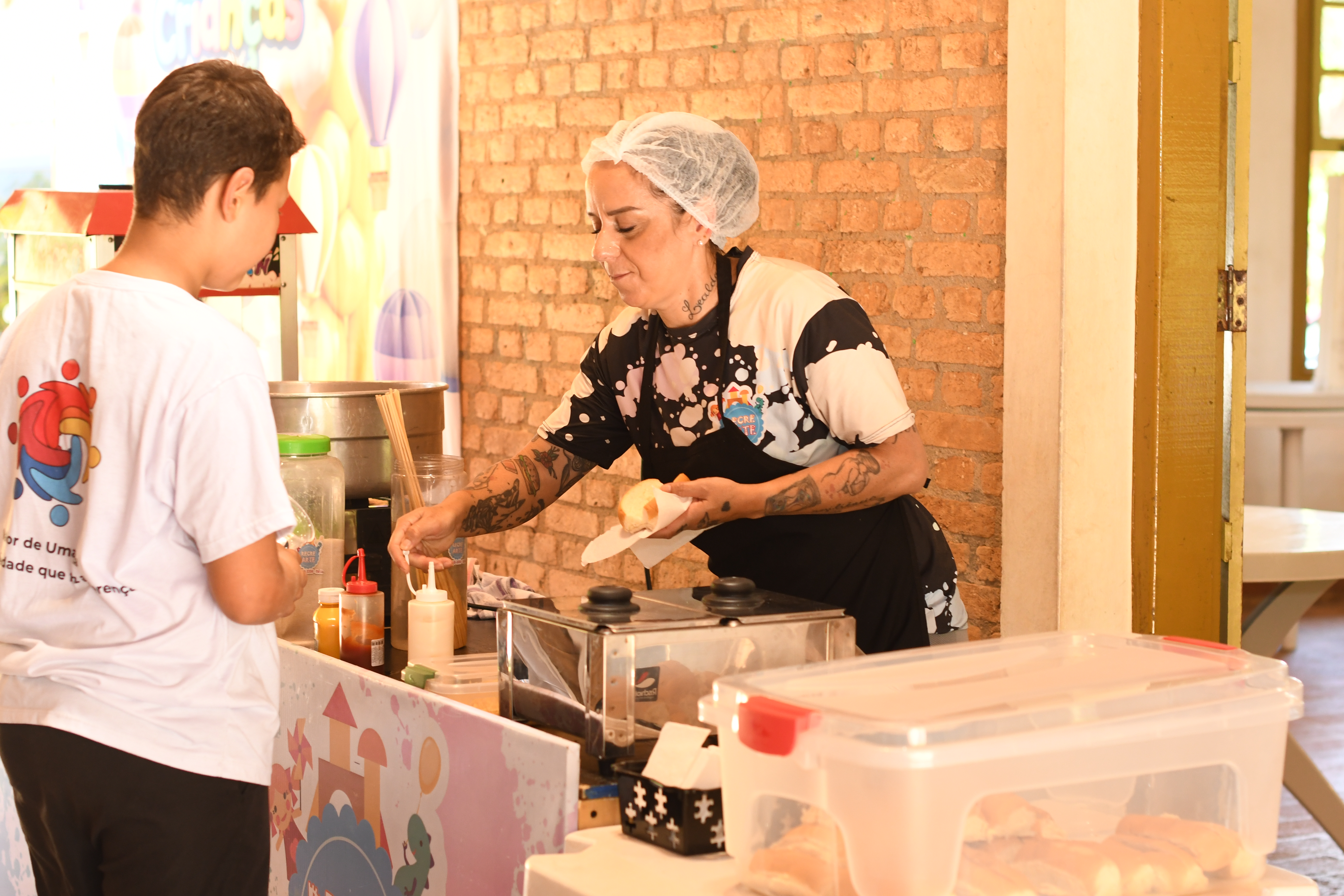 Preparo de cachorro quente para as crianças no evento